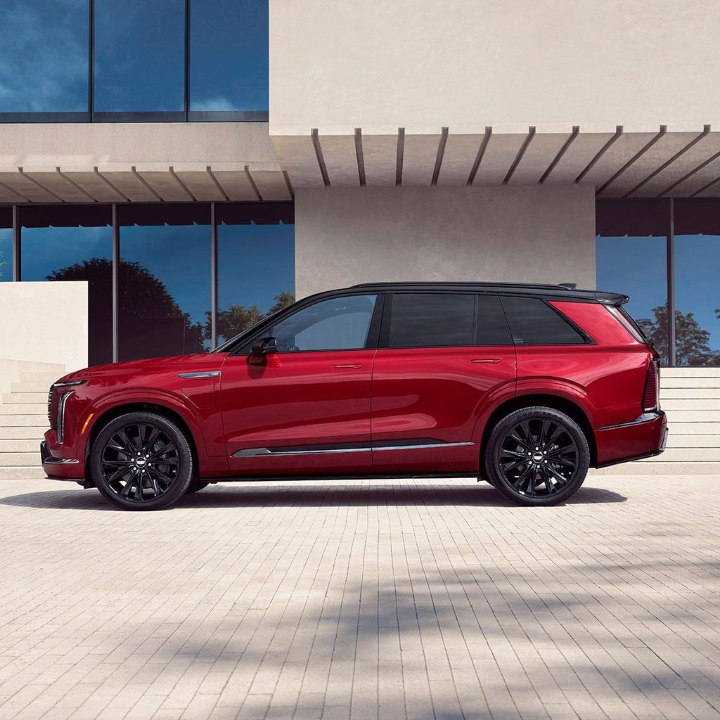 Red 2027 Cadillac VISTIQ electric SUV parked outside a modern building.