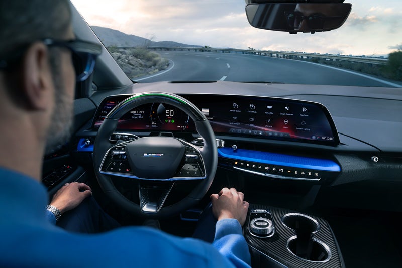 Front View of the 2026 OPTIQ-V Driving Through the Dusk Utilizing its Headlights | Wiesner of Huntsville in Huntsville TX